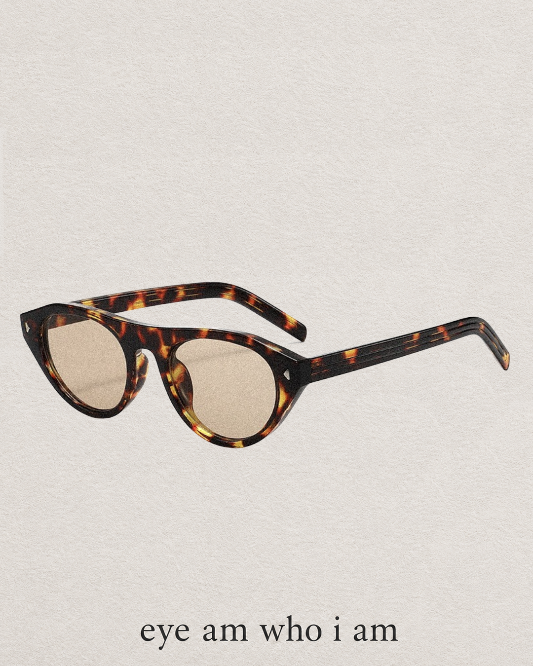 Tortoiseshell cat-eye sunglasses with light beige lenses, shown on a textured off-white background with the text 'eye am who i am' printed below.